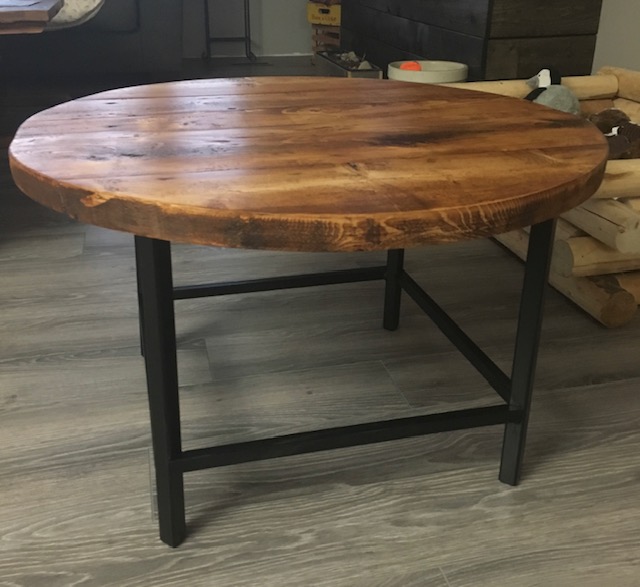 Round stained wood coffee table with black metal legs